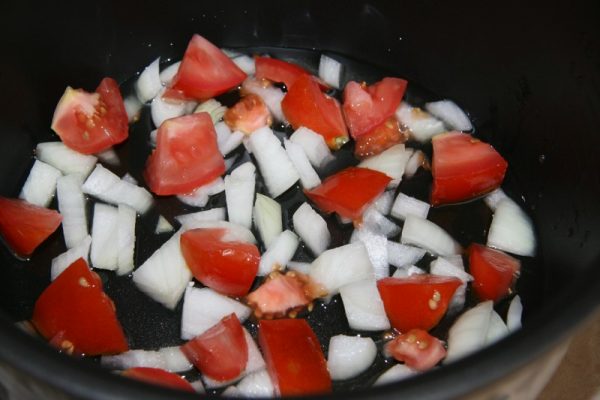 Нарежьте свежие помидоры и лук в чаше мультиварки